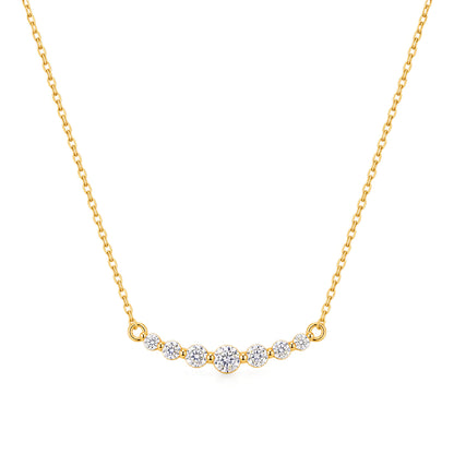 A delicate gold chain necklace featuring a curved bar pendant set with five small round-cut clear gemstones, displayed against a solid white background.