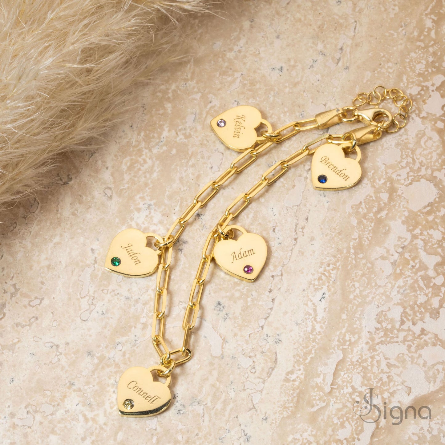 gold bracelet with heart-shaped charms on a textured surface